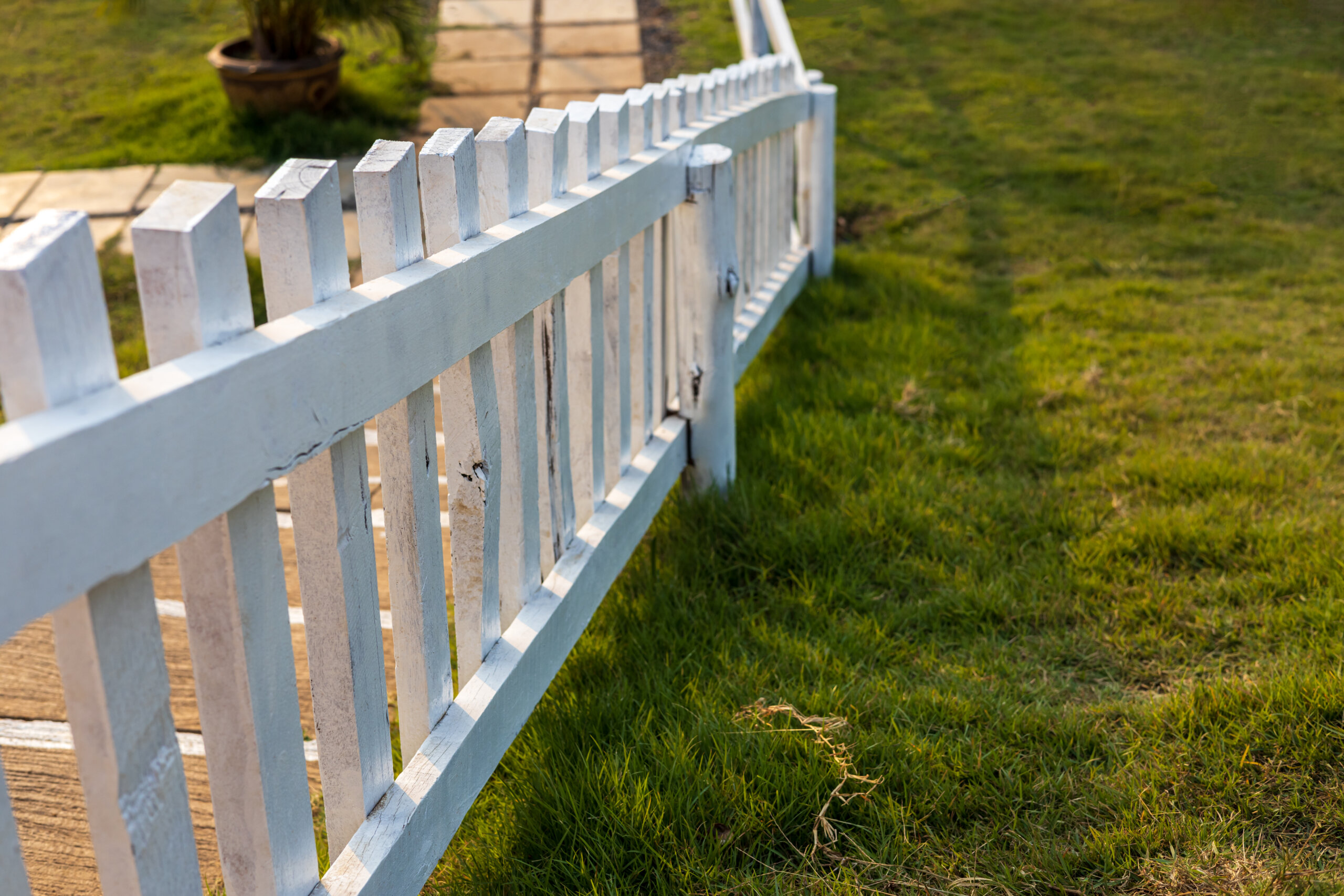 Close-up view of a white wooden fence installed against the sunl